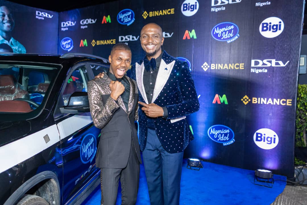 Progress Chukwuyem, winner of the Nigerian Idol Season 7, with a brand-new Sports Utility Vehicle (SUV), as part of the N100,000,000 (One Hundred Million Naira) worth of prizes won; IK Osakioduwa, the show’s host, at the grand finale of the music reality, sponsored by the Bigi carbonated soft drink brand of Rite Foods Limited.